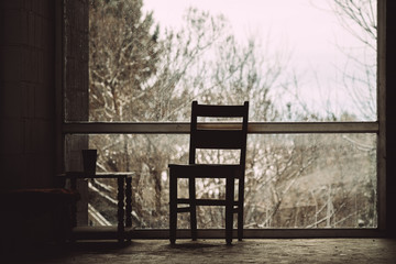 Single brown chair against backlit window