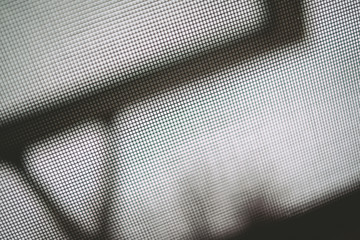 Close up of mesh screen with window showing through