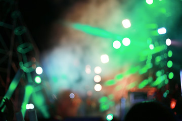 Fototapeta na wymiar Blurred background concert : Bokeh lighting in concert with audience, Music showbiz concept, music performance concert with bokeh spotlight. entertainment concert lighting on stage, blur disco party