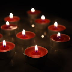 Burning candle isolated on black background.