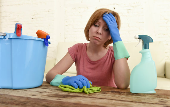 woman cleaning living room table with cloth and spray bottle tired in stress