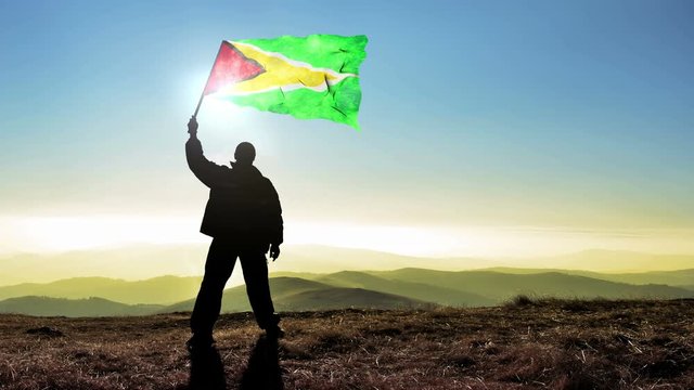 silhouette man waving Guyana flag 