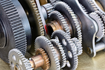 Fototapeta premium various gear cogwheels on scratched metal industrial background macro view