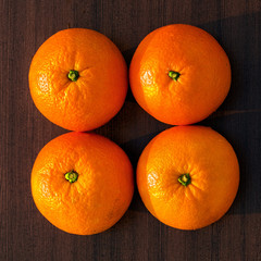 Four oranges on wooden background