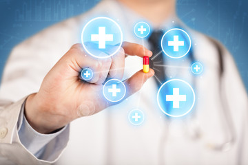 A doctor showing a pill with crosses