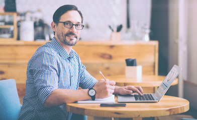 Pleasant cafe owner sitting at the table