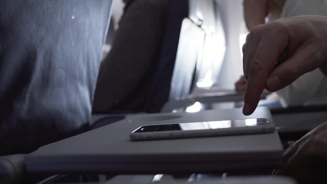 Man sitting in flying airplane and fun smartphone stock footage video