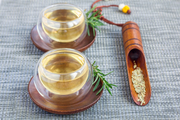 Herbal rosemary tea in a glass cup on oriental background, horizontal