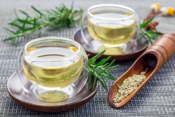 Herbal rosemary tea in a glass cup on oriental background, horizontal