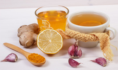Cup of tea with lemon and ingredients for preparation warming beverage