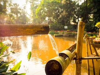 Bamboo lengths of pipe set up to direct water, Bamboo water fountain