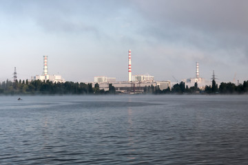 Fototapeta na wymiar Kursk Nuclear Power Plant reflected in a calm water surface.