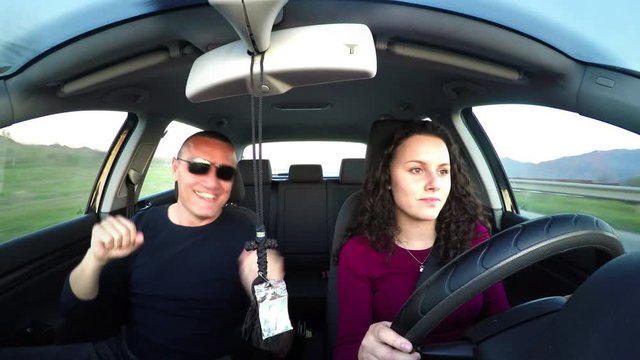 father dancing while daughter driving