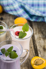 Smoothies or yogurt with fresh berries on a wooden table.