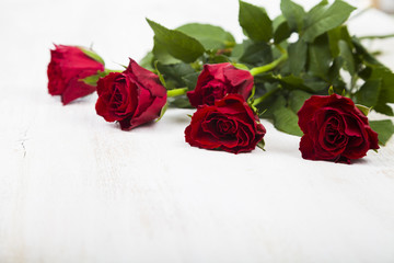 Red roses on a wooden background.