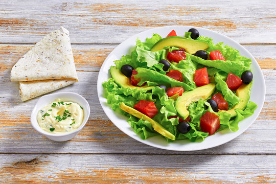 slamon salad with sauce and pita, side view