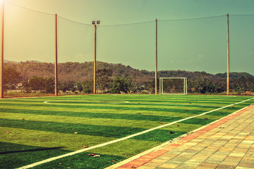 Artificial turf football field with vintage color filter and sunlight 