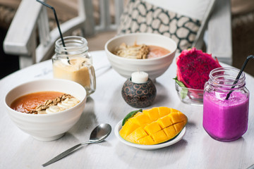 Healthy Raw Fruit Breakfast on White Rustic Table. Color Smoothie with Mango and Pitaya Fruits.