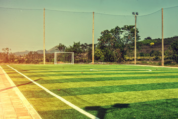 Artificial turf football field with vintage color filter and sunlight 