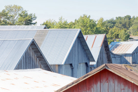 Roofs of corrugated iron on gray and red decayed boathouses
