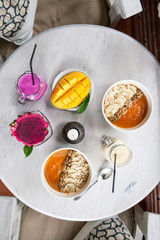 Healthy Raw Fruit Breakfast on White Rustic Table. Color Smoothie with Mango and Pitaya Fruits.