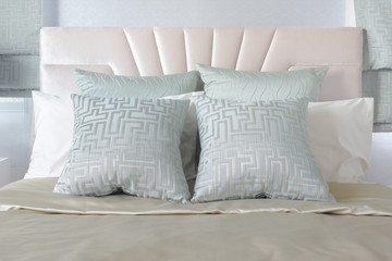 Fototapeta na wymiar Pastel color of pillows setting on bed with satin bedding style