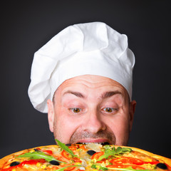 Portrait of happy attractive cook with a pizza