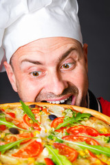 Portrait of happy attractive cook with a pizza