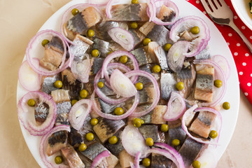 Sliced herring on a white plate and boiled potatoes