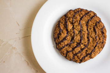 Oatmeal cookies with chocolate on a white plate. Tasty dessert.