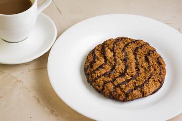 Oatmeal cookies with chocolate on a white plate. Tasty dessert.