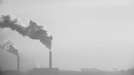 smoke from the chimney of an industrial enterprise on a background of blurred city