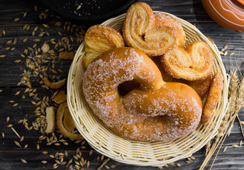 Pretzel in sugar and biscuits Berliner on a wooden table in rustic style and ingredients. Tasty dessert.
