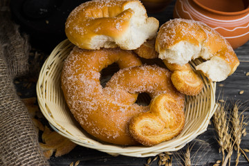 Pretzel in sugar and biscuits Berliner on a wooden table in rustic style and ingredients. Tasty dessert.