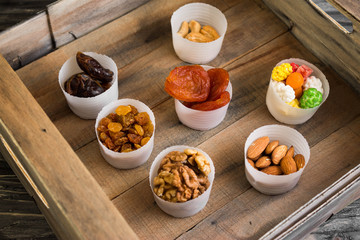 Nuts and dried fruits in a box on a wooden table in rustic style