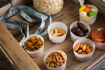 Nuts and dried fruits in a box on a wooden table in rustic style