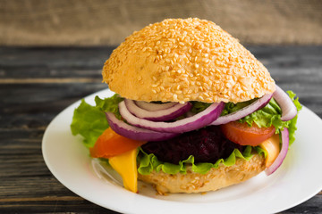 Hamburger with beetroot Cutlets on a wooden table and ingredients