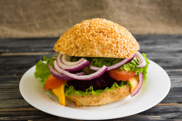 Hamburger with beetroot Cutlets on a wooden table and ingredients