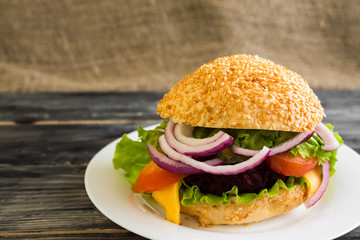 Hamburger with beetroot Cutlets on a wooden table and ingredients