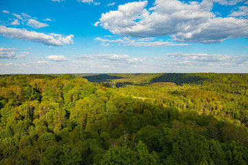 Beautiful sky and clouds over hills with green forest, covered by sunshine. Gauja river, Latvia.