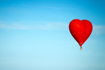 Fototapeta na wymiar hot air balloon in the shape of heart flying in the blue sky