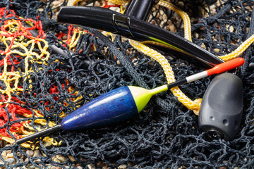 Wooden fishing float with fishing rod reel and fish tank on the stony ground © Vladimir Zhupanenko