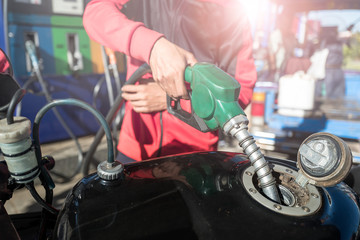 Close up of man's hand holding fuel pump and refueling car in Gas station