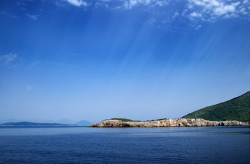 Fototapeta na wymiar Sunrays over an island and the ocean