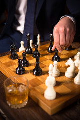 Closeup of chessboard with white and black chess pieces on. Man ready to play with partner. Business concept. Competition and rivalry concepts.