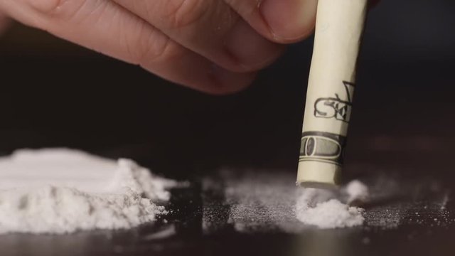 DRUGS: Man inhales a heroin via US dollar - Front view