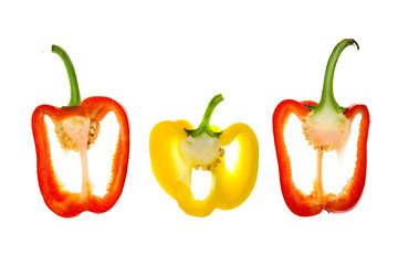 Two red and one yellow cut bell peppers on white background
