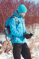 Boy using the mobile phone during the winter trip