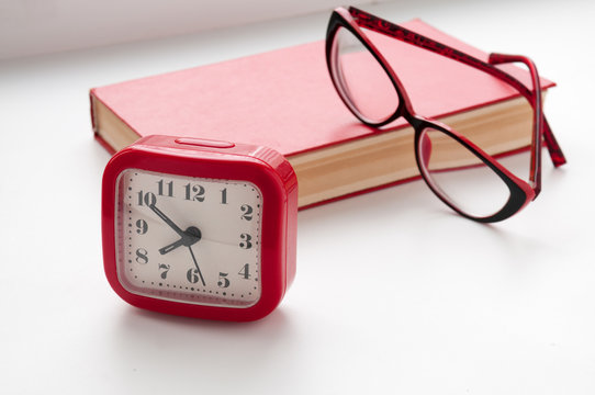 The Red Book, glasses and watch on a light background