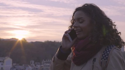 Beautiful female student talking to friend by phone with happy smile on face - Powered by Adobe